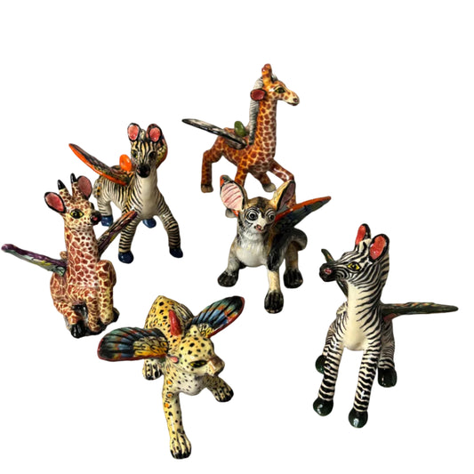 A set of hand-painted figurines depicting various animals, including zebras, giraffes, a leopard, and a bush baby. Christmas tree ornaments or nursery ornaments. 