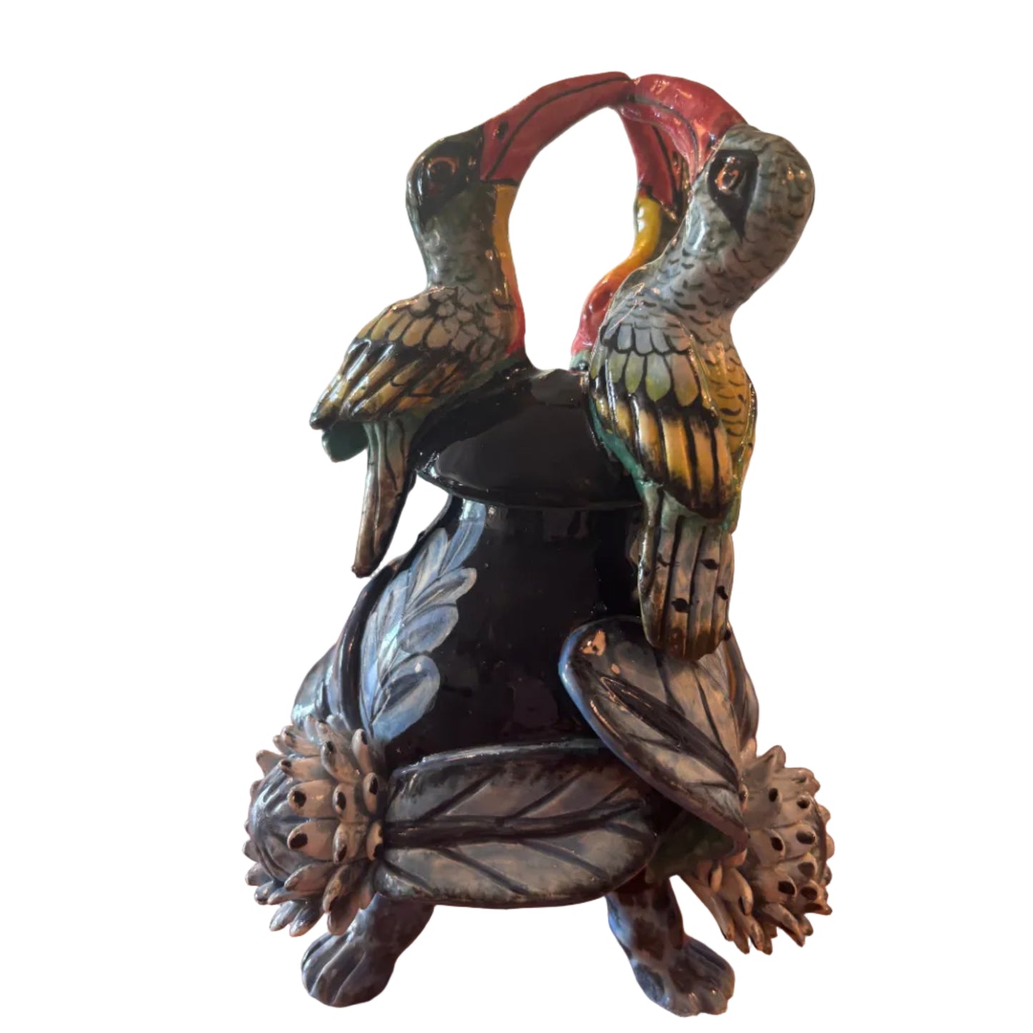 Decorative sculpture of two parrots on a branch with a wreath of flowers.
