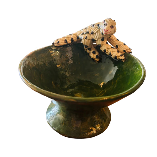 Green ceramic bowl with a decorative pangolin figurine 