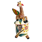 A decorative ceramic figurine featuring a stylized giraffe perched atop a cylindrical pot-like base with painted floral and leaf motifs, photographed on a light gray studio background.